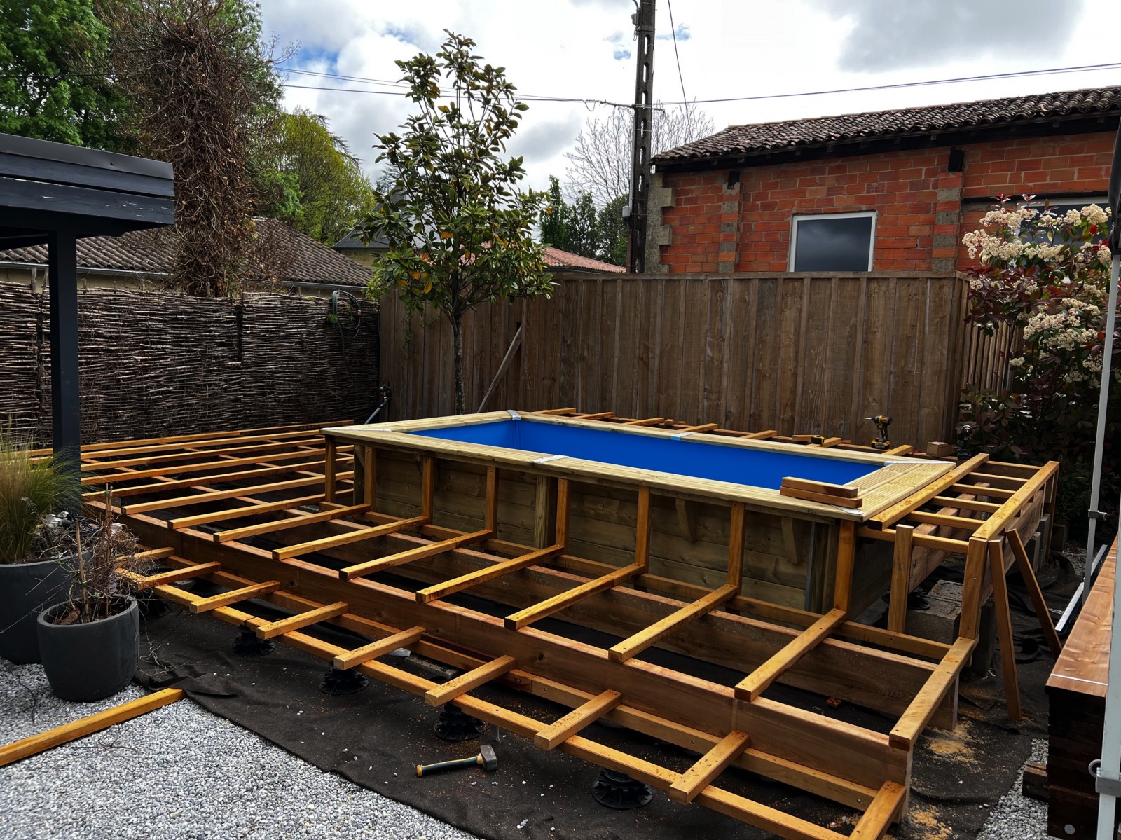 réalisation d'une structure complexe et résistante avec des marches autour d'une piscine hors sol pour réceptionné des lames de terrasse a bordeaux