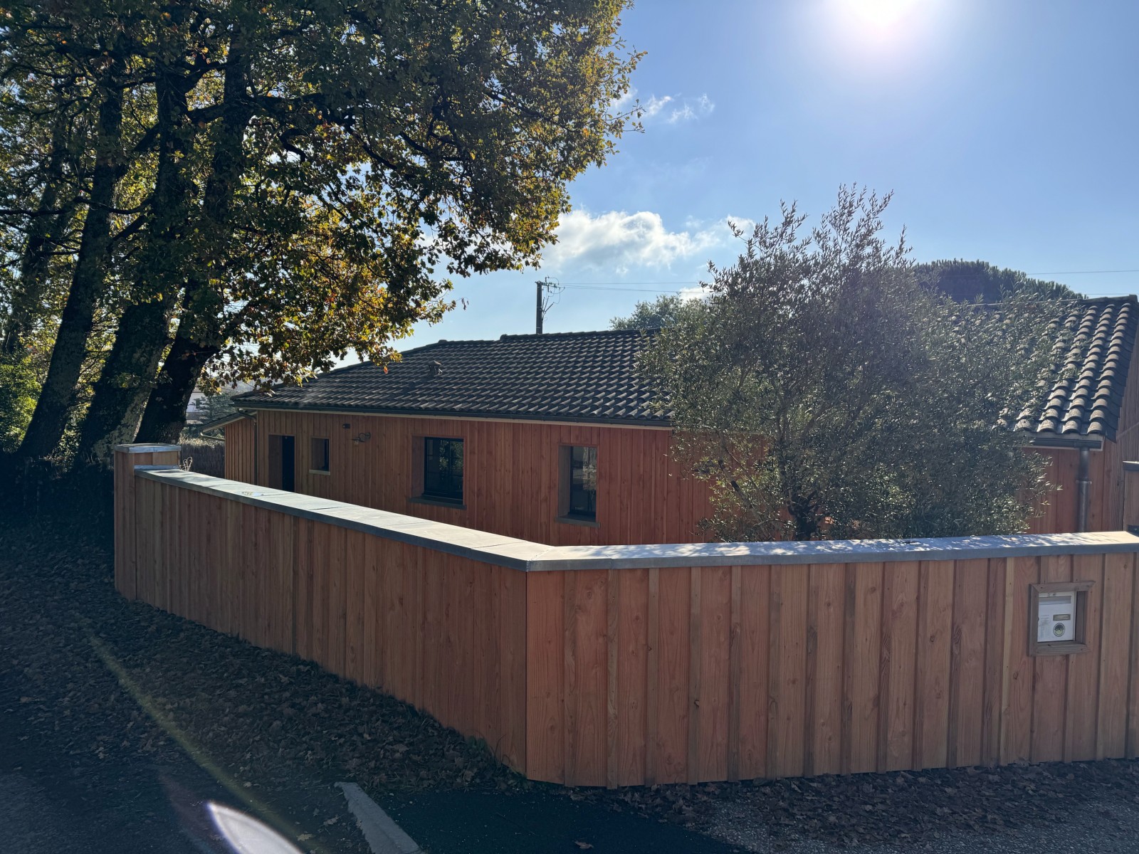 Aménagement extérieur en bois Douglas près de Bordeaux Installation d’une clôture sur mesure en bois Douglas naturel, offrant intimité et cachet à l’entrée de la maison. Couvertine en zinc pour une protection optimale contre les intempéries en région bord