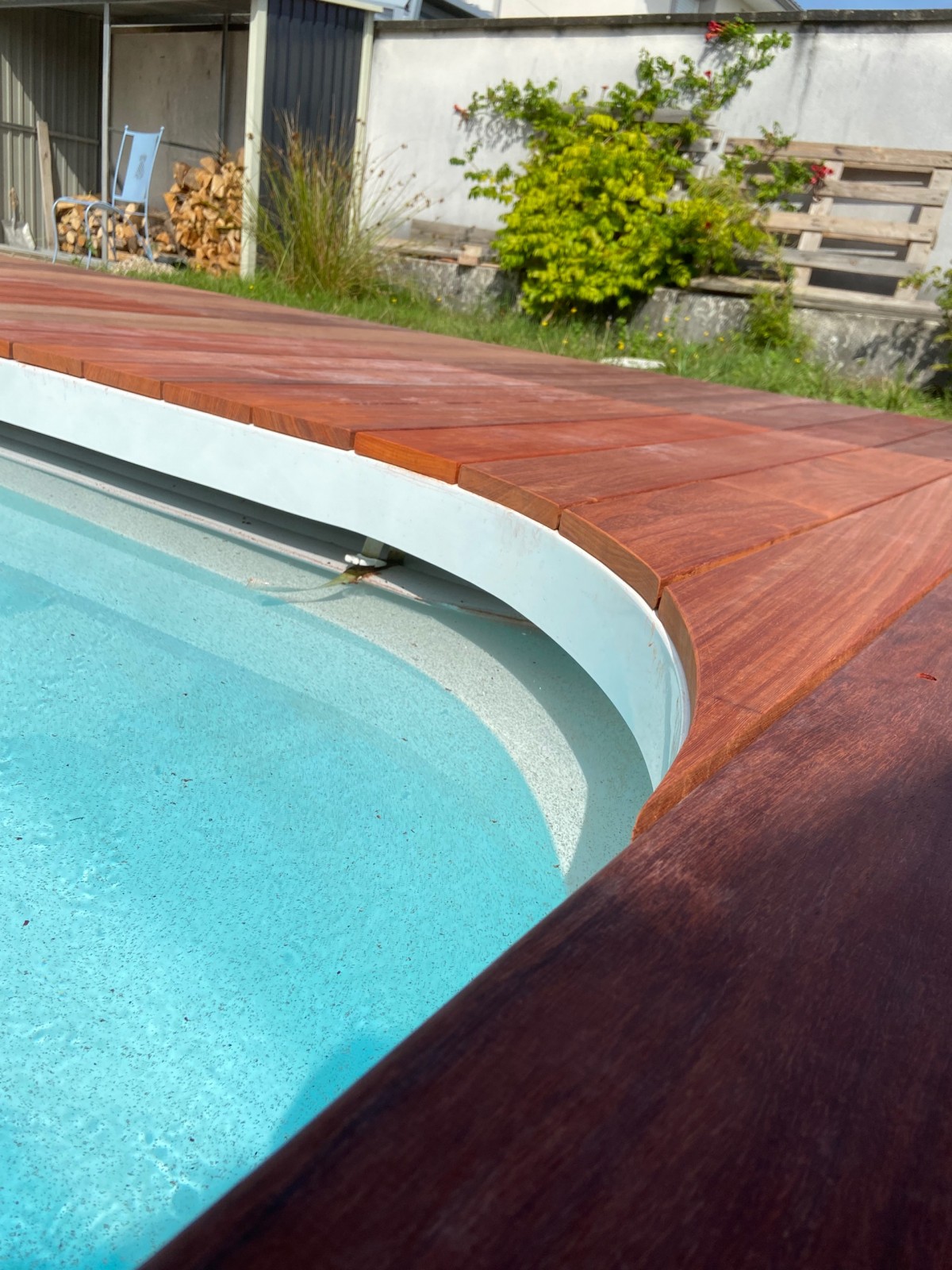 Création d’une terrasse en bois exotique padouk de 65 m² avec caillebotis et trappe pour la pompe de la piscine intégré dans la terrasse à tresses près de Bordeaux