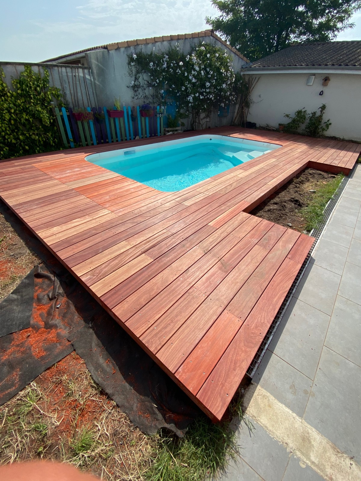 Création d’une terrasse en bois exotique padouk de 65 m² avec caillebotis et trappe pour la pompe de la piscine intégré dans la terrasse à tresses près de Bordeaux