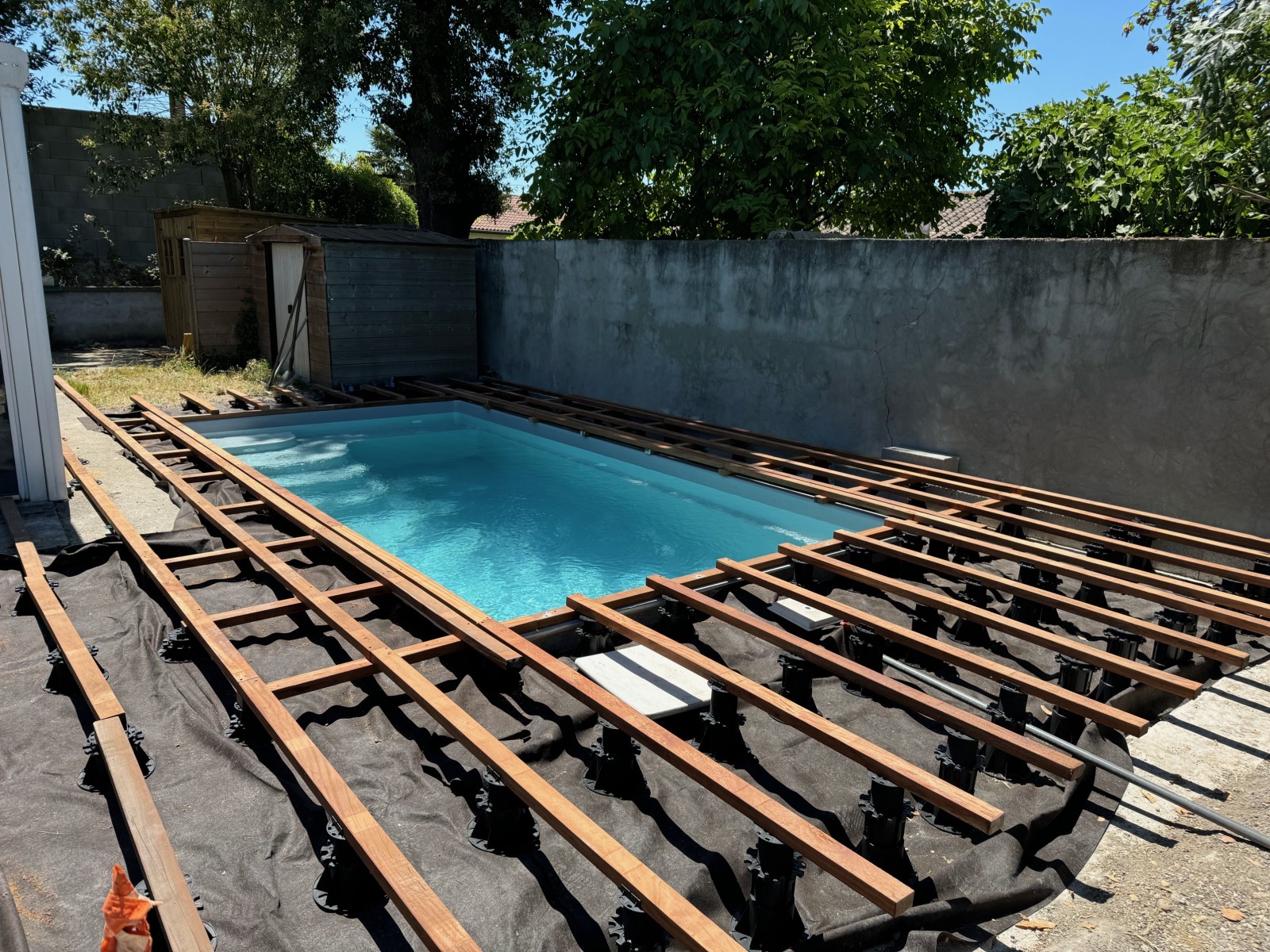 Installation plots PVC réglables et géotextile sous terrasse cumaru