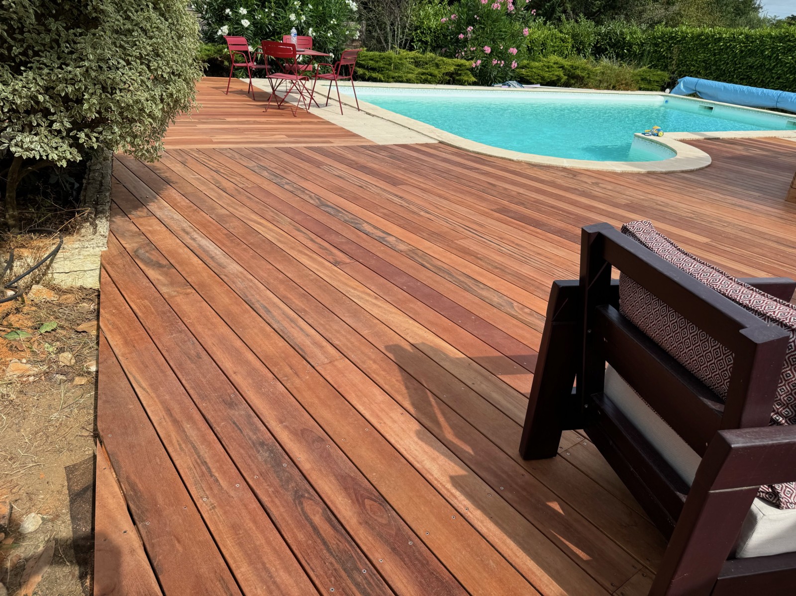 Alliez confort et style : Profitez de votre piscine avec cette terrasse en Tiger Wood de 120 m², dotée d'une trappe coulissante pour un accès pratique au local technique.